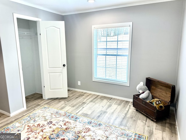 living area featuring ornamental molding and light hardwood / wood-style floors