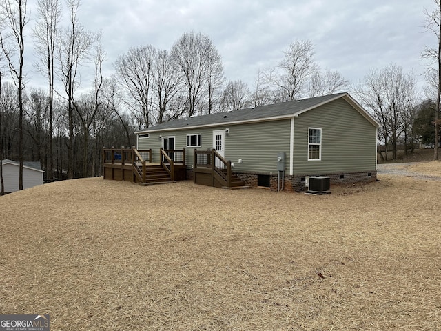 rear view of property featuring a wooden deck and cooling unit