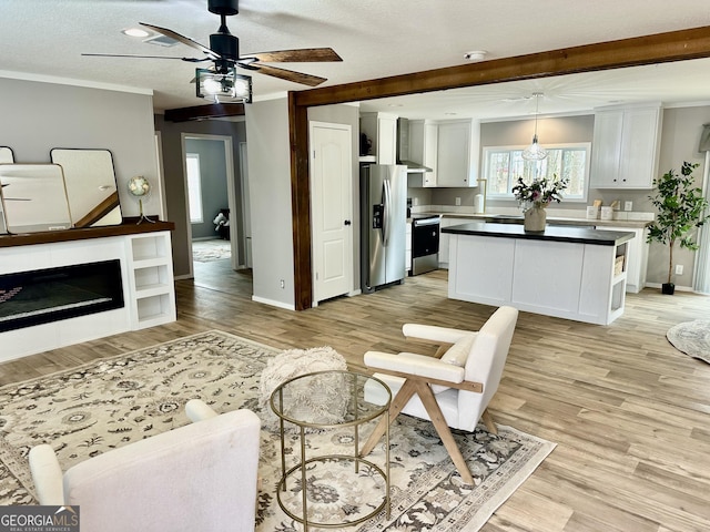 living room featuring ornamental molding, ceiling fan, and light hardwood / wood-style floors