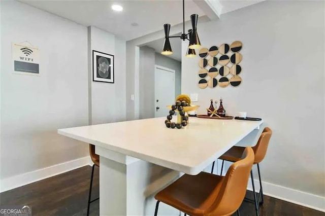 kitchen featuring a breakfast bar area, dark hardwood / wood-style flooring, and kitchen peninsula