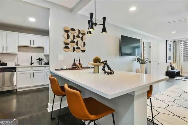 kitchen with pendant lighting, white cabinetry, a breakfast bar area, backsplash, and stainless steel dishwasher