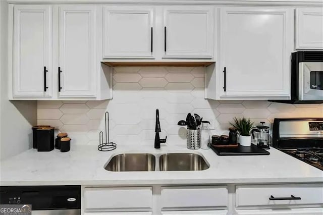 kitchen featuring gas range, dishwasher, sink, and white cabinets