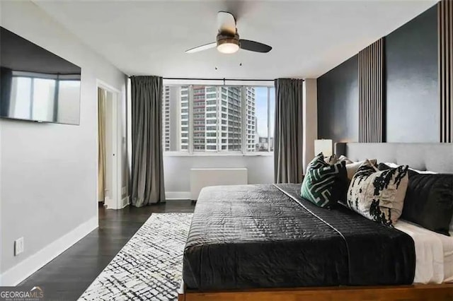 bedroom with dark hardwood / wood-style flooring and ceiling fan