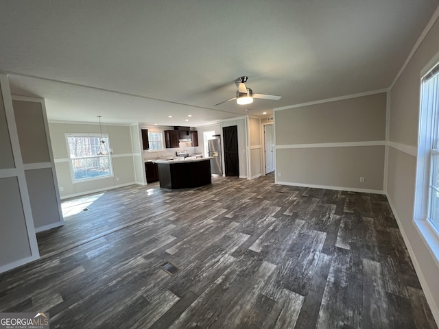 unfurnished living room with crown molding, ceiling fan, and dark hardwood / wood-style flooring