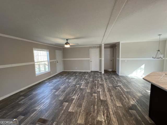 unfurnished living room featuring crown molding, ceiling fan with notable chandelier, dark hardwood / wood-style floors, and a textured ceiling