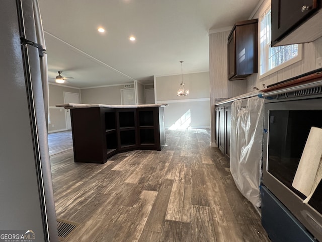 kitchen featuring stainless steel refrigerator, hanging light fixtures, dark hardwood / wood-style floors, dark brown cabinetry, and ceiling fan with notable chandelier