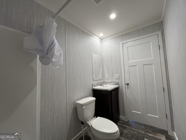 bathroom with vanity, toilet, hardwood / wood-style floors, and a textured ceiling