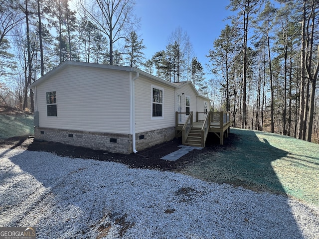 view of side of property featuring a wooden deck and a yard