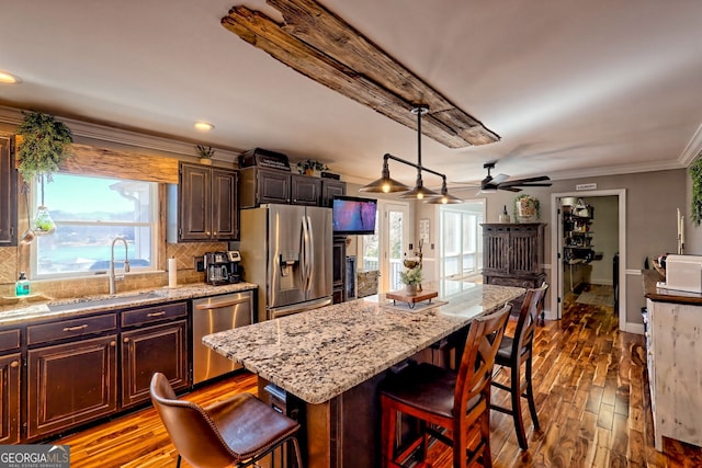 520 Long View Dr, Hiawassee, GA 30546 - kitchen with stainless steel appliances, a ceiling fan, a breakfast bar area, a sink, and ornamental molding