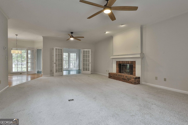 unfurnished living room featuring a brick fireplace, light colored carpet, and french doors