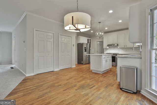 kitchen featuring pendant lighting, stainless steel appliances, white cabinets, and a kitchen island