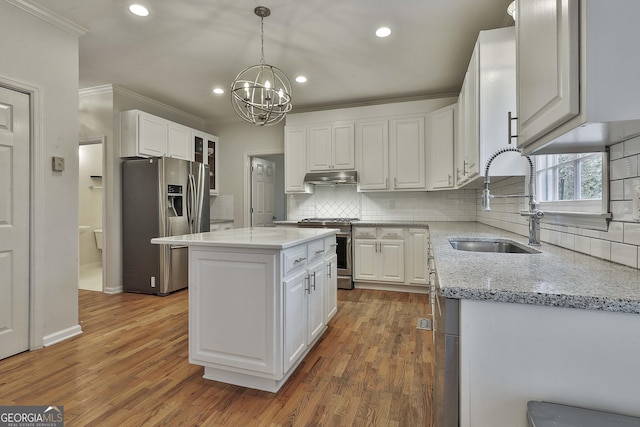 kitchen with stainless steel appliances, white cabinetry, a center island, and sink