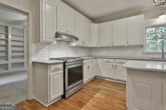 kitchen with white cabinetry, ornamental molding, stainless steel gas range, and light stone counters