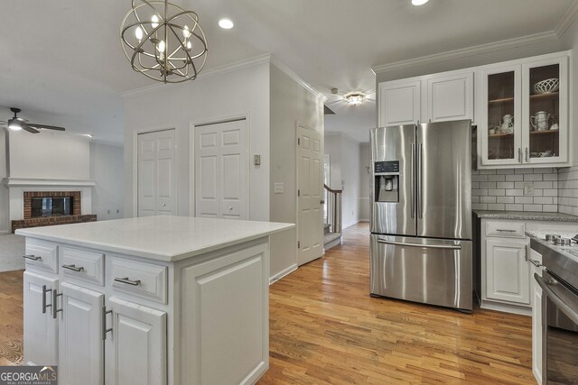 kitchen featuring a kitchen island, decorative light fixtures, ventilation hood, white cabinetry, and decorative backsplash