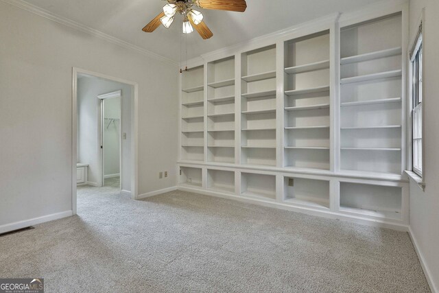 interior space featuring crown molding, ceiling fan, light carpet, and built in features