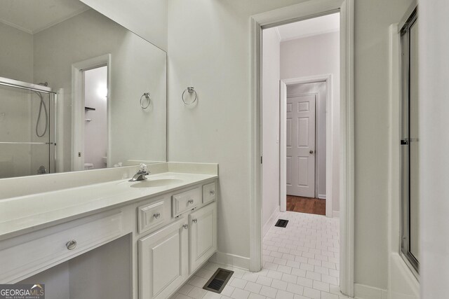 bathroom with tile patterned flooring, vanity, a shower with door, and toilet