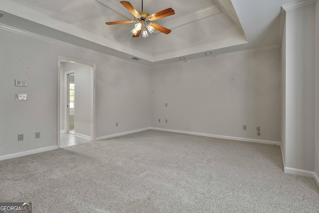 carpeted empty room featuring crown molding, ceiling fan, and a tray ceiling