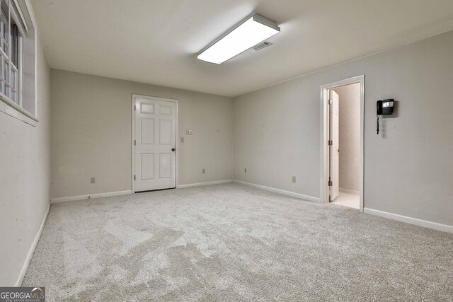 unfurnished bedroom featuring light carpet and two closets