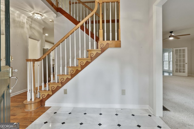 staircase featuring carpet floors and ceiling fan