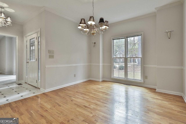 unfurnished dining area featuring an inviting chandelier, crown molding, and light wood-type flooring