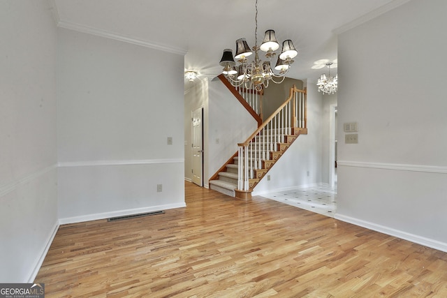 interior space with wood-type flooring, a notable chandelier, and crown molding