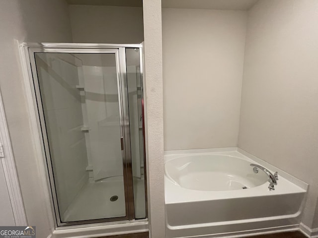 bathroom featuring shower with separate bathtub