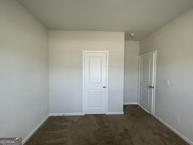 unfurnished bedroom featuring dark carpet