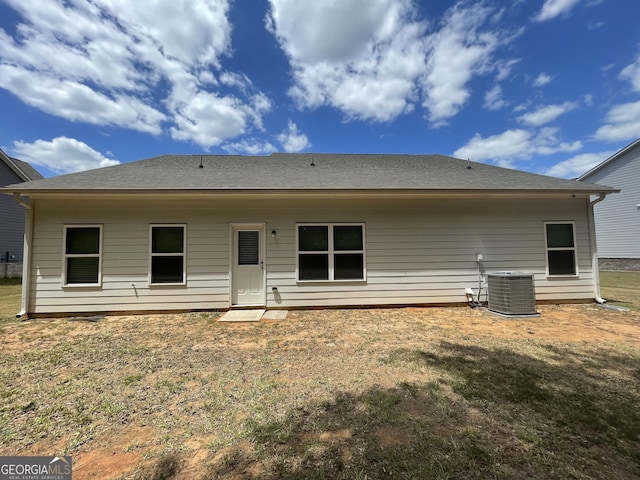 rear view of house featuring a lawn and central air condition unit