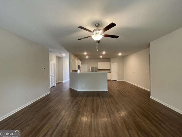 unfurnished living room featuring dark wood-type flooring and ceiling fan