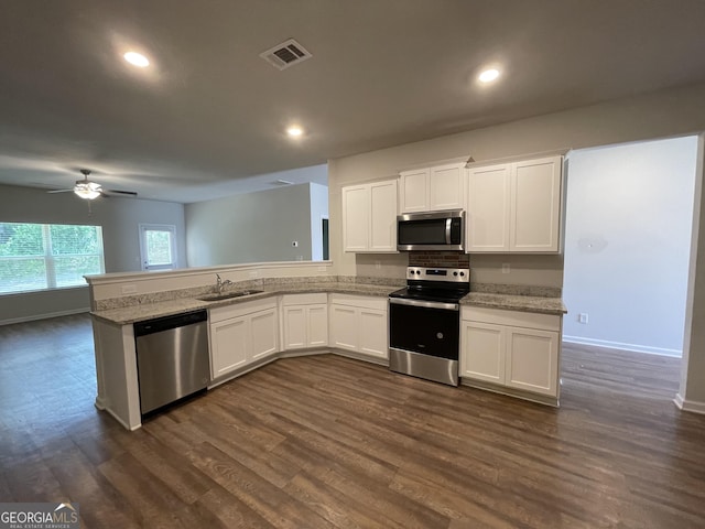 kitchen featuring sink, white cabinetry, stainless steel appliances, dark hardwood / wood-style flooring, and kitchen peninsula