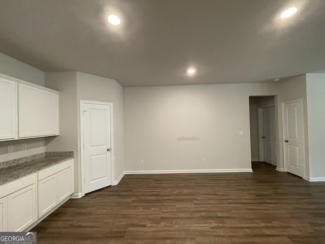 interior space featuring dark hardwood / wood-style flooring, white cabinets, and stone counters