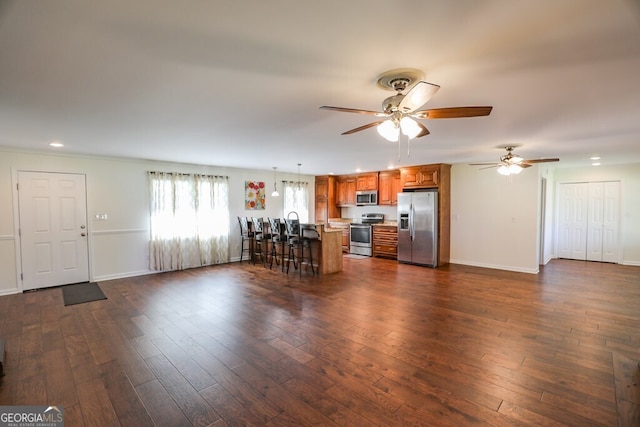 unfurnished living room featuring ceiling fan and dark hardwood / wood-style flooring