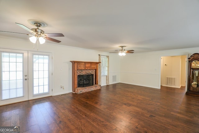 unfurnished living room featuring dark hardwood / wood-style flooring, a brick fireplace, and ornamental molding