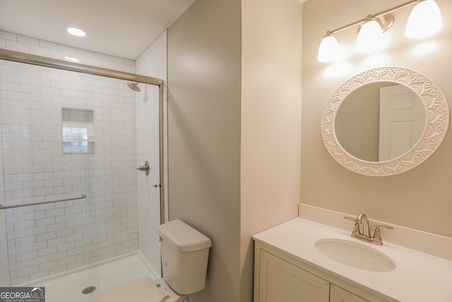 bathroom featuring vanity, toilet, and a shower with door