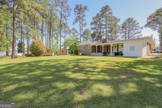 back of property featuring a porch and a lawn