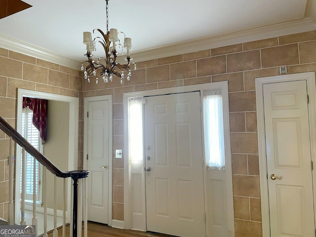 entrance foyer featuring crown molding and a chandelier