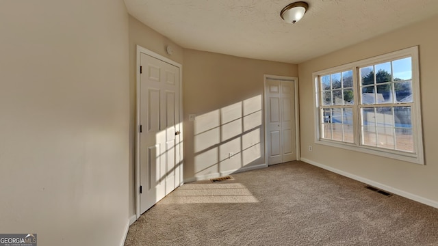 carpeted spare room featuring a textured ceiling