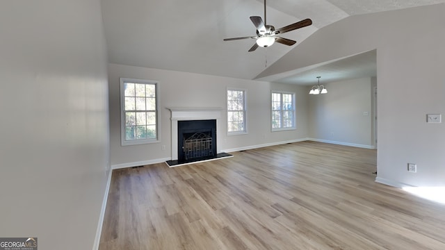 unfurnished living room with ceiling fan, a healthy amount of sunlight, light hardwood / wood-style flooring, and lofted ceiling