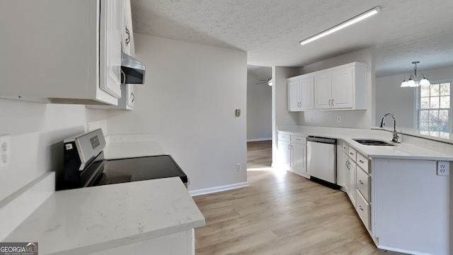 kitchen featuring pendant lighting, sink, appliances with stainless steel finishes, white cabinetry, and a textured ceiling