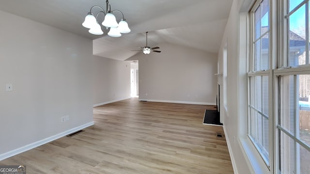 unfurnished living room with lofted ceiling, ceiling fan with notable chandelier, and light hardwood / wood-style flooring