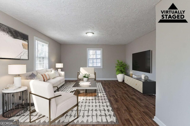 living room featuring dark wood-type flooring and a textured ceiling