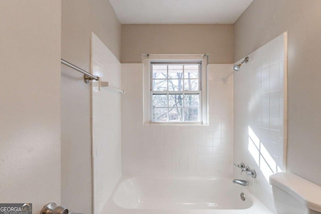 bathroom with tiled shower / bath and toilet