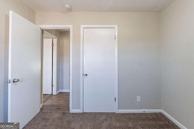 unfurnished bedroom featuring dark colored carpet