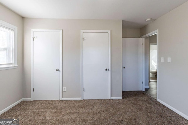 unfurnished bedroom with dark colored carpet