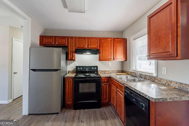 kitchen with sink, light hardwood / wood-style flooring, and black appliances