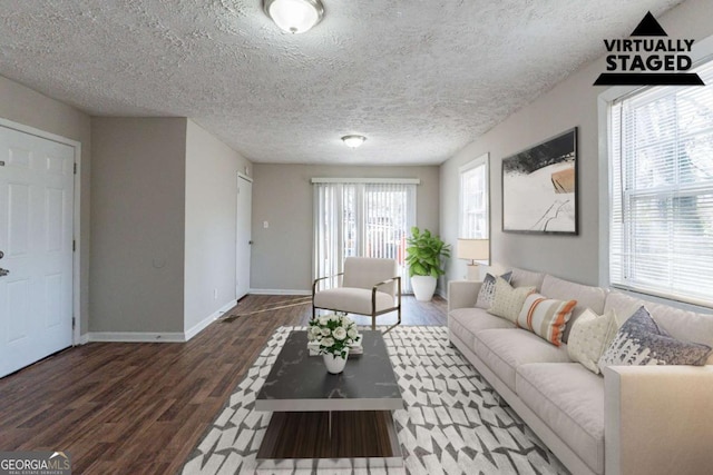 living room with dark hardwood / wood-style floors and a textured ceiling