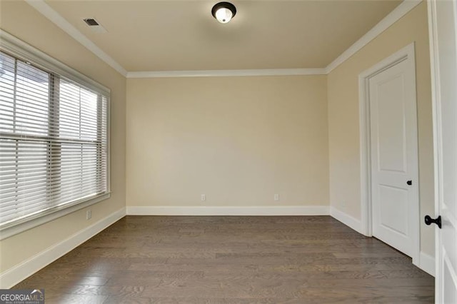 empty room with ornamental molding and dark hardwood / wood-style flooring