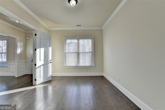 spare room with dark wood-type flooring, a wealth of natural light, and ornamental molding