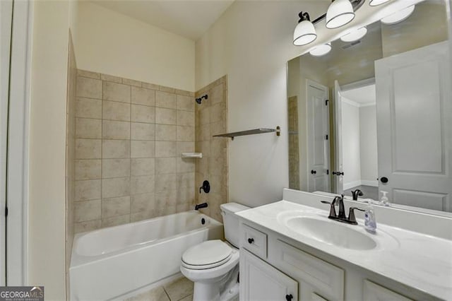 full bathroom featuring tiled shower / bath, vanity, toilet, and tile patterned flooring