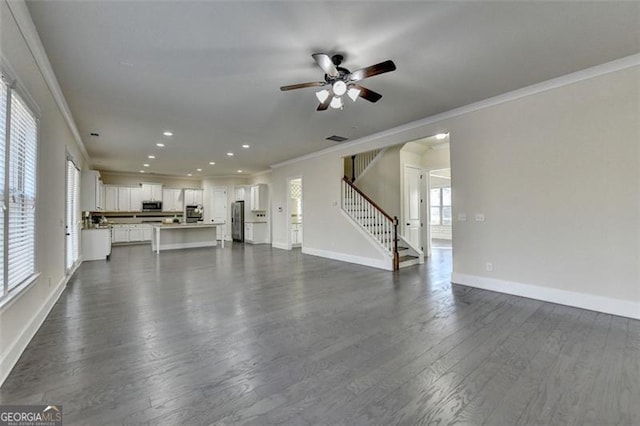 unfurnished living room with crown molding, ceiling fan, and dark hardwood / wood-style flooring